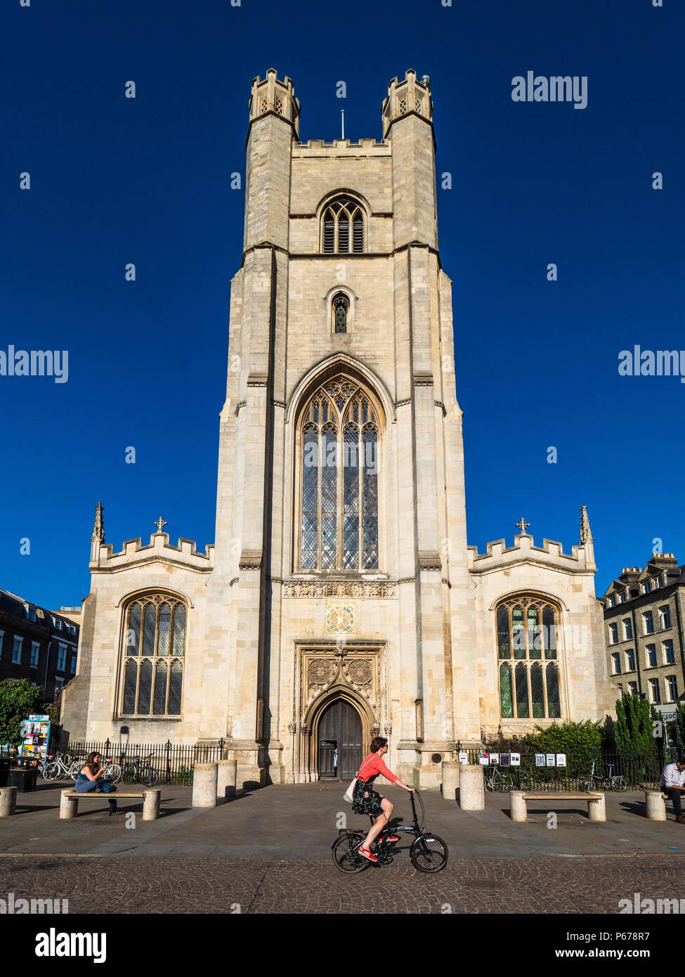 Cambridge Tourism - cyclists pass Great St Mary's church in central Cambridge. The church, rebuilt after a fire in 1290, is Cambridge University Churc Stock Photo