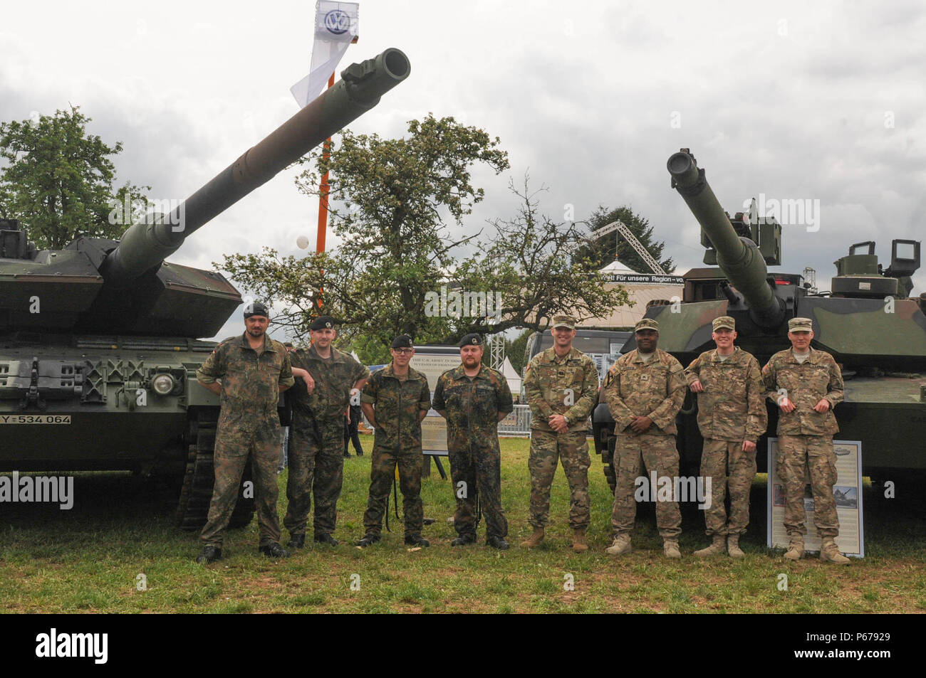 German soldiers assigned to Panzer Battalion 203 of Panzer Brigade 21, 1st Panzer Division and U.S. soldiers assigned to 2nd Battalion,7th Infantry Regiment, 1st Armored Brigade Combat Team, 3rd Infantry Division pose in front of the German Leopard II A6 tank and the American M1A2 Abrams Main Battle Tank at Hessentag ‘16 in Herborn, Germany on May 21, 2016. The Hessian Day or ‘Hessentag’ is an annual festival that showcases culture, traditions, businesses and the citizenry of the German state. (Photo by Sgt. 1st Class Jason Epperson, 4th ID Public Affairs) Stock Photo