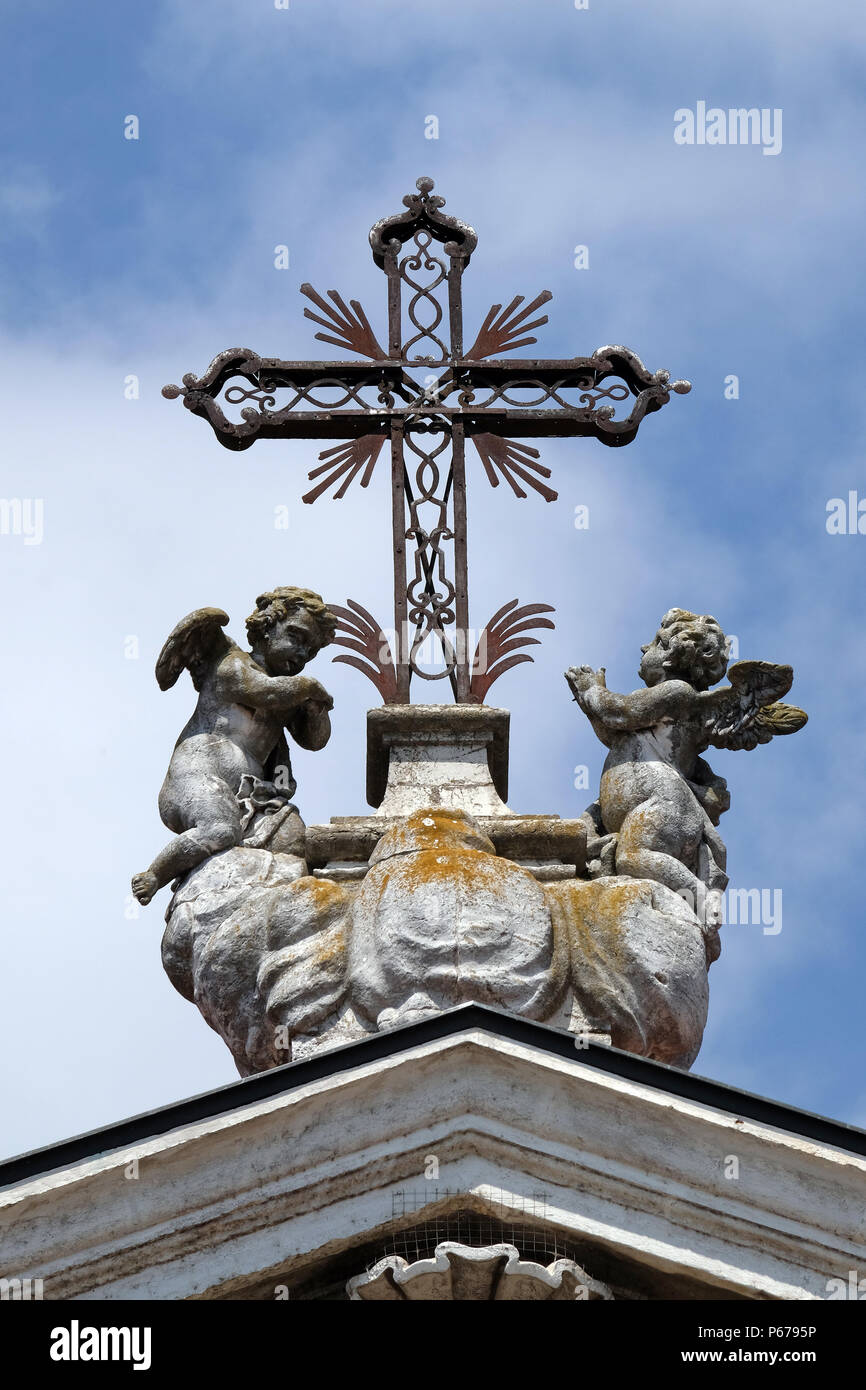 Angels kneeling under the cross, statue on facade of the Mantua Cathedral dedicated to Saint Peter, Mantua, Italy Stock Photo