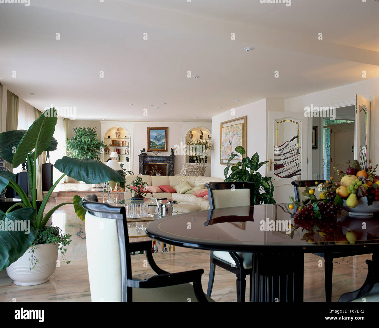 View of a spacious living room with an adjoining dining area Stock