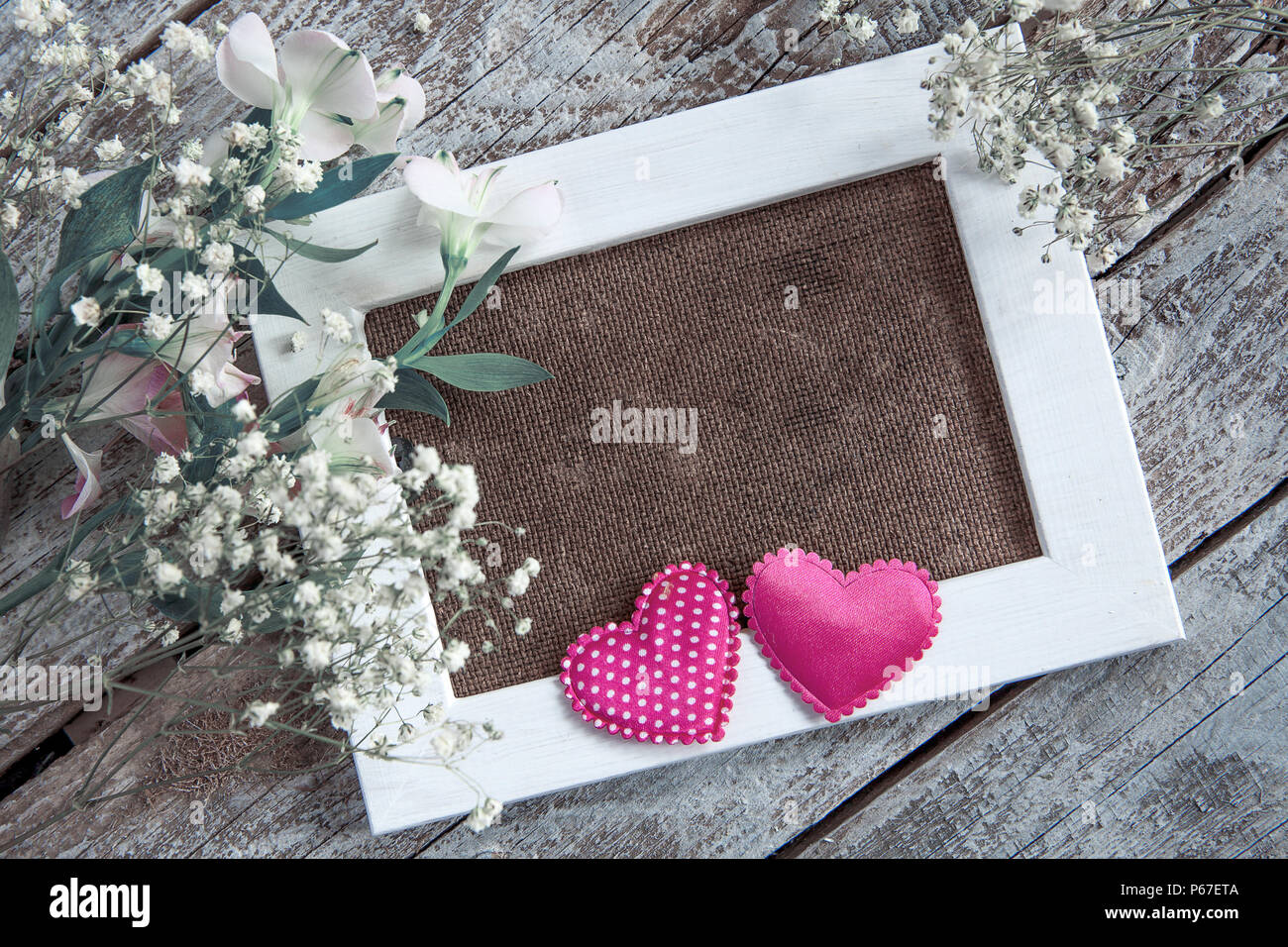 Blank photo frame and white flowers over wooden table background Stock Photo