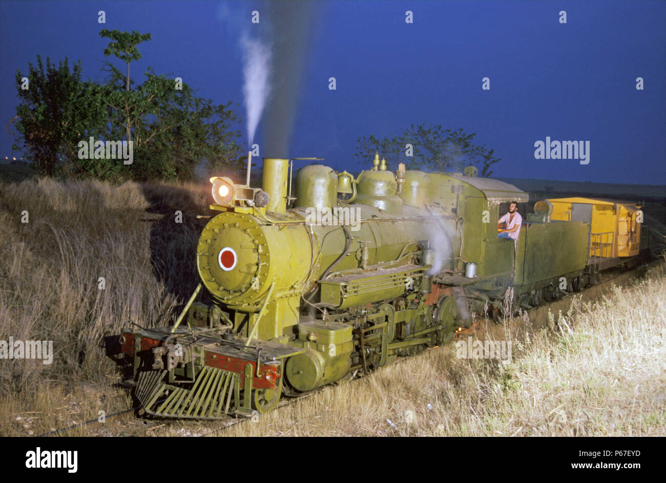 Baldwin 2-8-0 N0.1661 of 1920 vintage belongs to Cuba's George Washington mill and is basking amid the sugar plantations at twilight. With yellow cabo Stock Photo