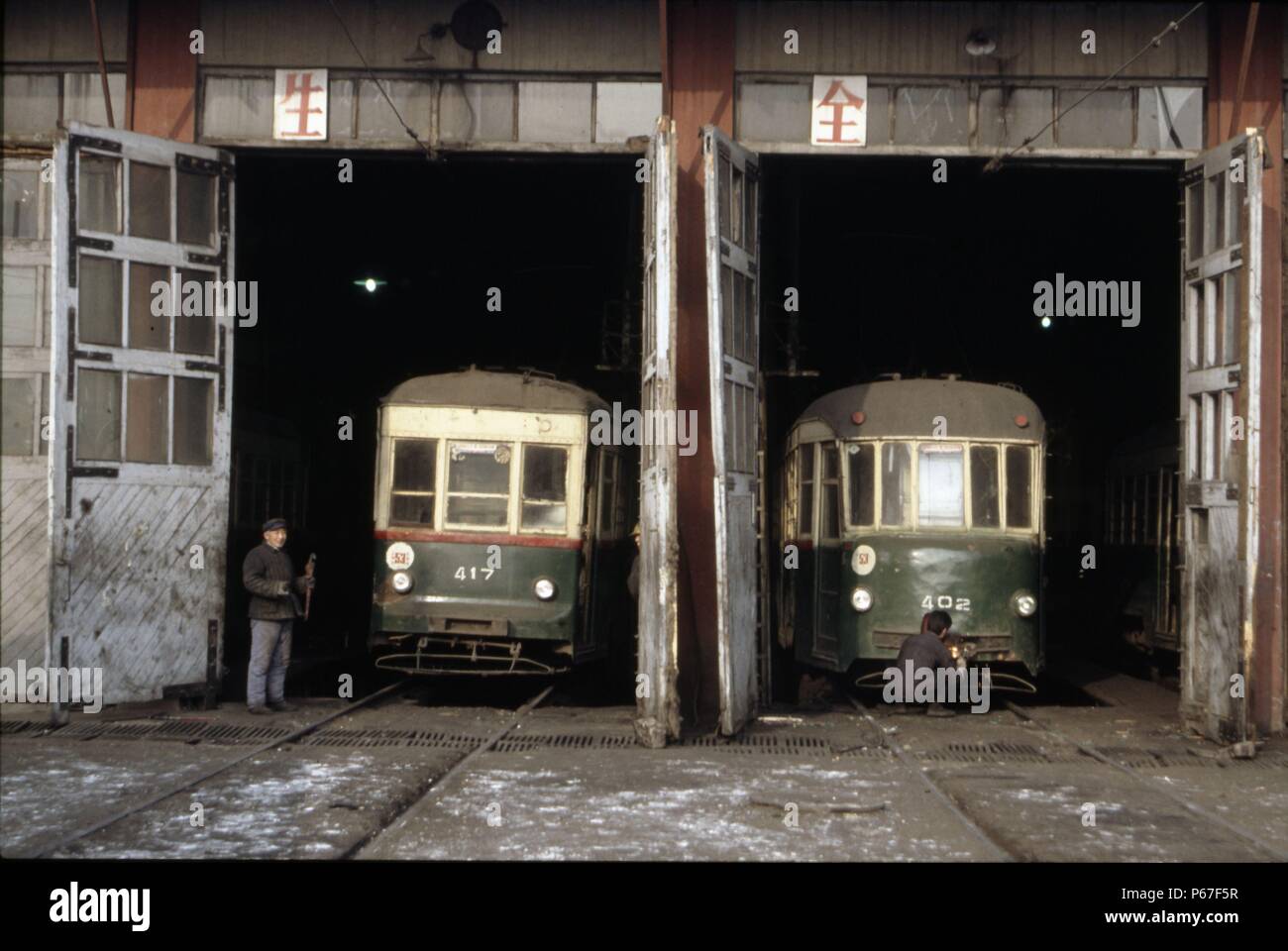By the early 1990s Changchun's once magnificent tramway network was badly rundown. This scene at the tramshed shows two vehicles which were still in o Stock Photo