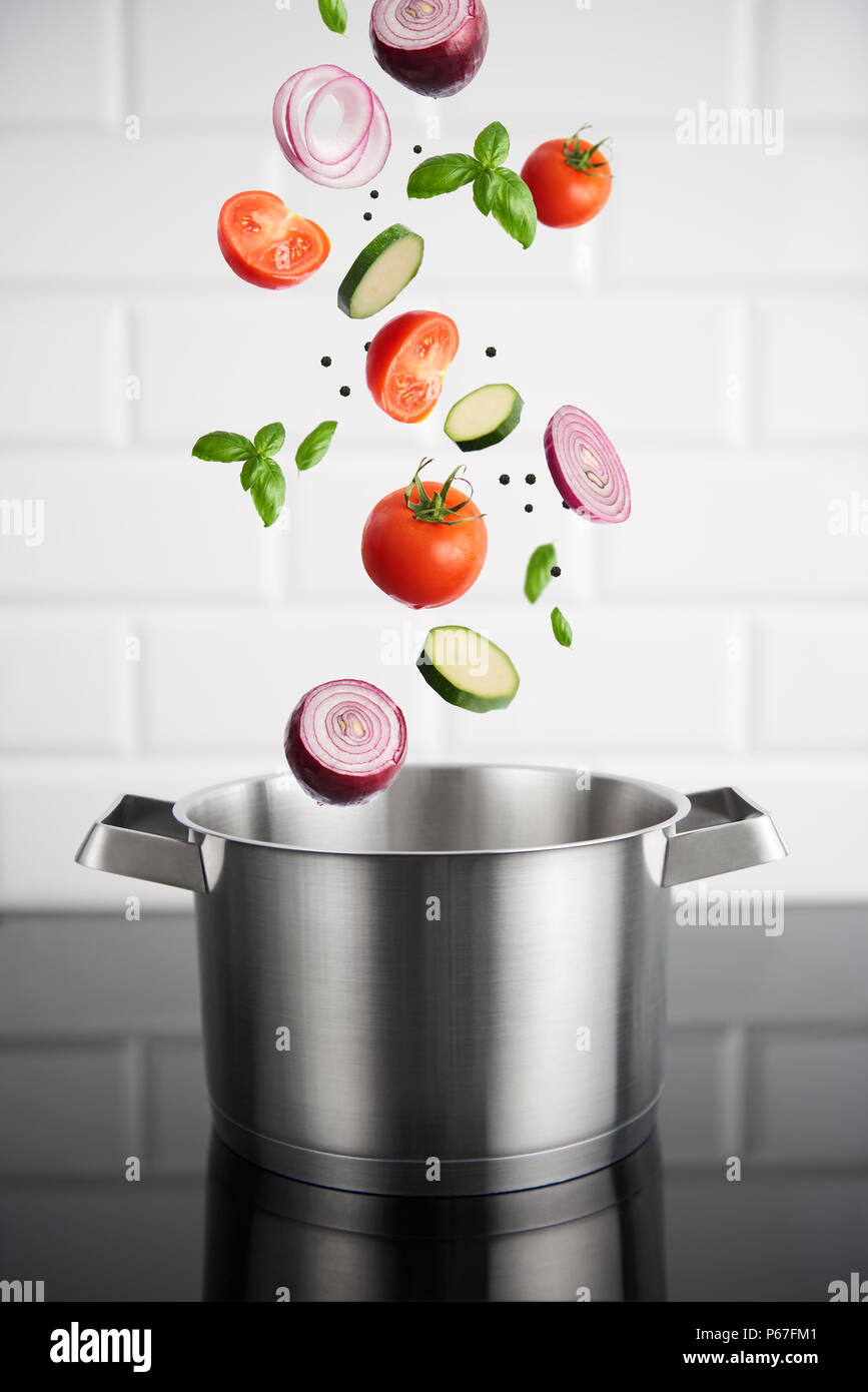 Healthy eating. Stainless steel pot with vegetables on the induction stove  with white metro tiles in the background. High resolution product Stock  Photo - Alamy