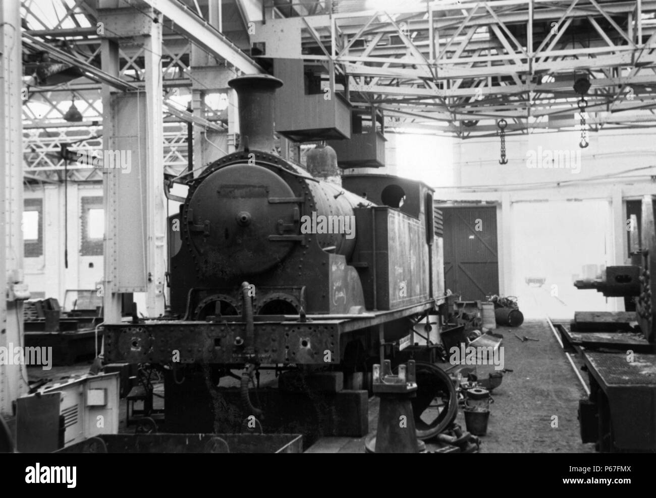 Eastleigh Works in the early 1960s with an ex LSWR Drummond M7 0-4-4T under overhaul. Stock Photo