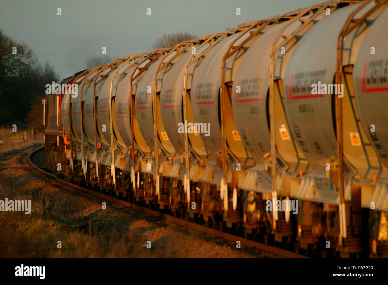 In The Golden Glow Of The Early Evening Sun An Ews Class 66 Heads A Rake Of Cement Hoppers Through Rearsby In The Leicestershire Countryside March Stock Photo Alamy