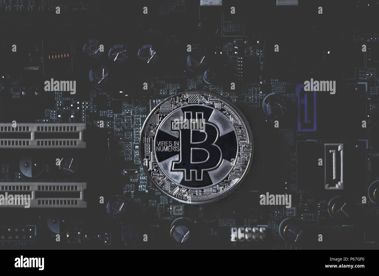 Real silver bitcoin  on dark toned integrated circuit background Stock Photo