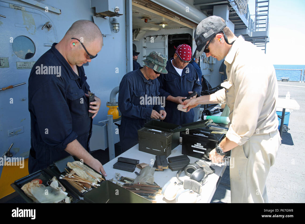 160509-N-IX266-012 SOUTH CHINA SEA—Civilian mariners Robert J. Blandford (right), chief mate aboard the fleet replenishment oiler USNS John Ericsson (T-AO 194) and Christopher Athanas, ordinary seaman (left), inventory ammunition prior to a small-arms weapons qualification course here, May 5. (U.S. Navy photo by Grady T. Fontana/Released) Stock Photo