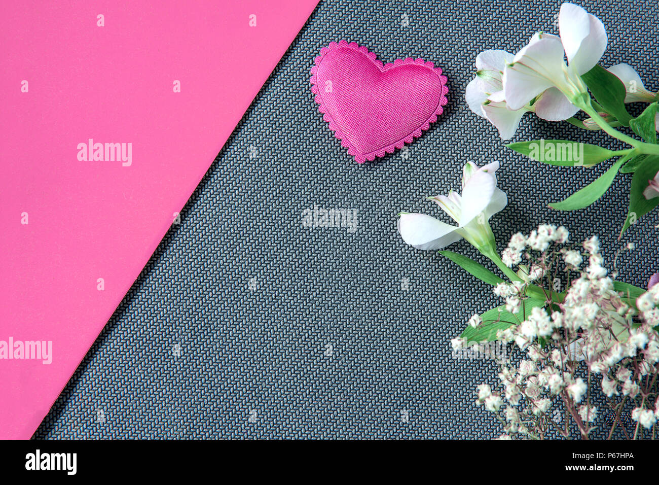 Heart and beautiful flowers on grey and pink background Stock Photo