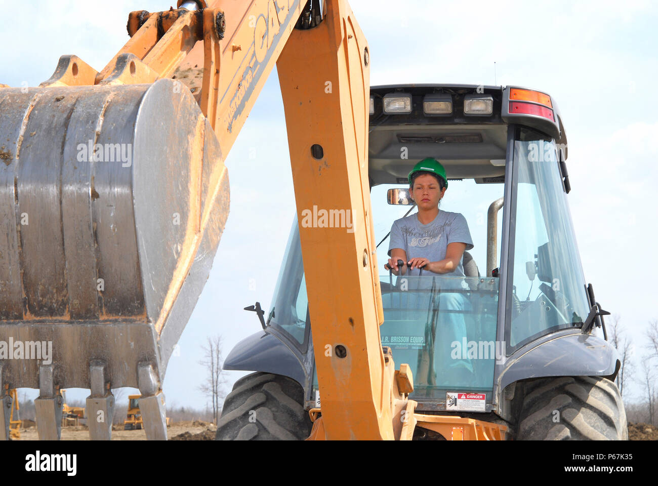 Woman operating backhoe excavator at training facility, Prescott, Ontario, Canada Stock Photo