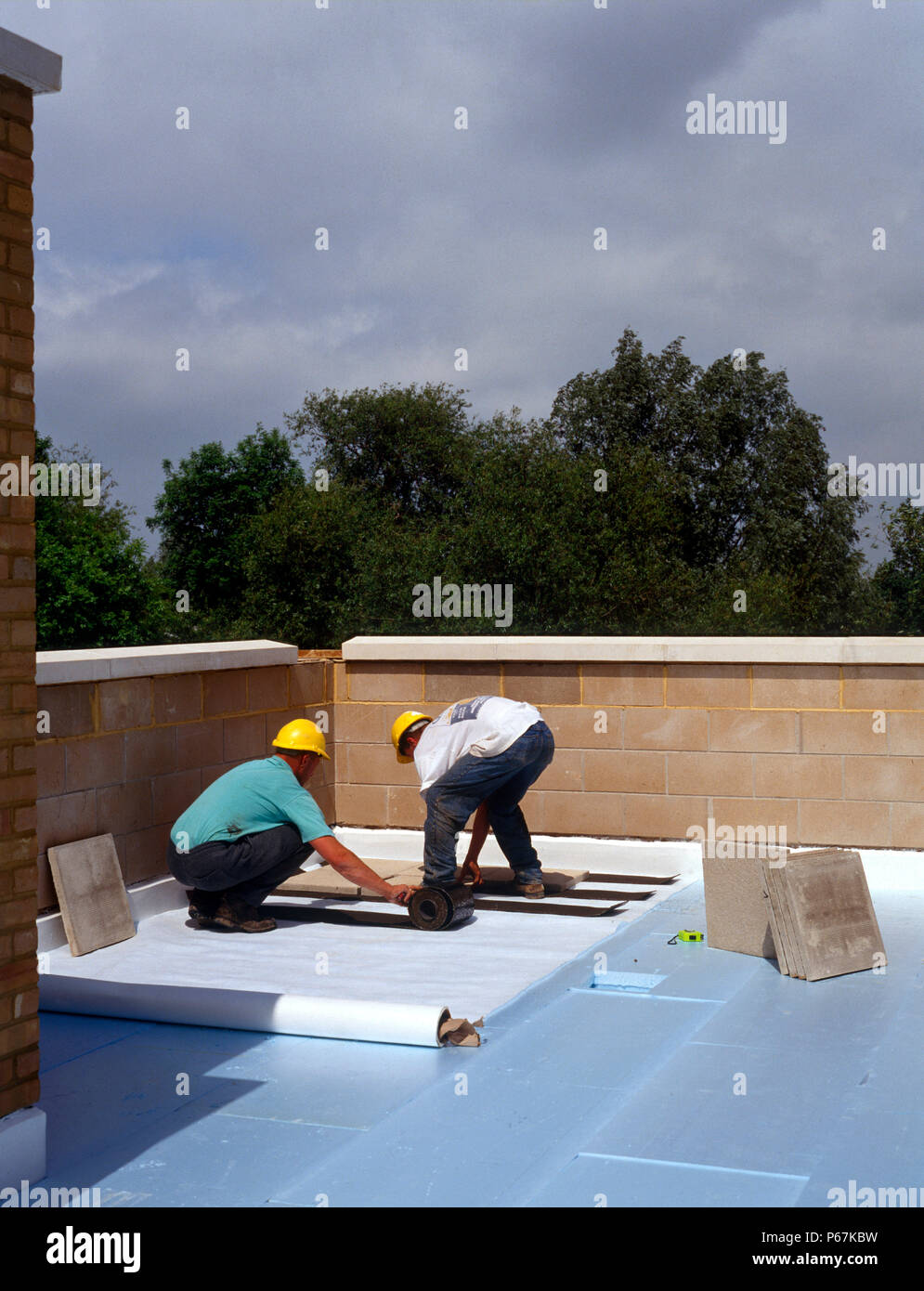 Construction worker insulating flat roof hires stock photography and