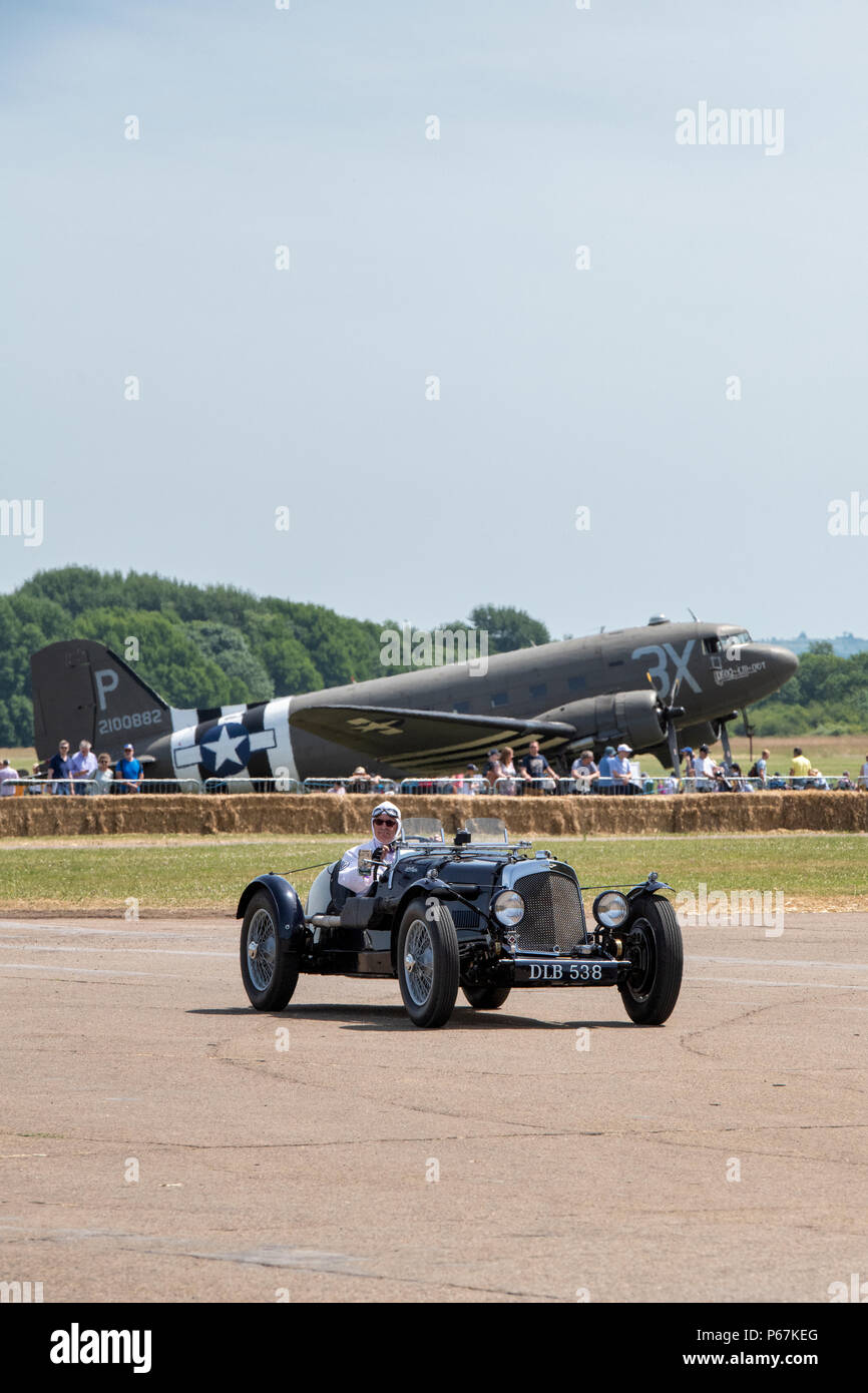1936 Vintage Aston Martin in front of a Douglas Dakota aircraft at the Bicester flywheel festival, Bicester Heritage centre, Oxfordshire, England Stock Photo