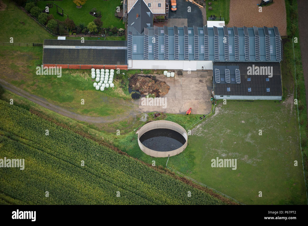 GERMANY aerial view of farm homestead with slurry tank and stable with solar roof in Northern Germany Stock Photo