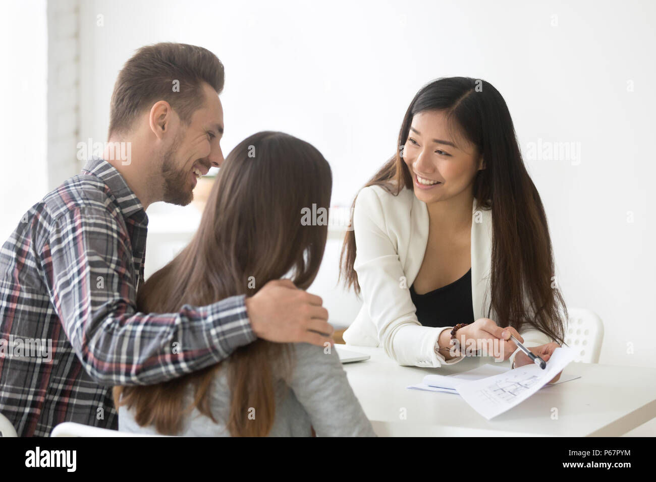 Smiling real estate agent talking to couple buying home together Stock Photo Alamy