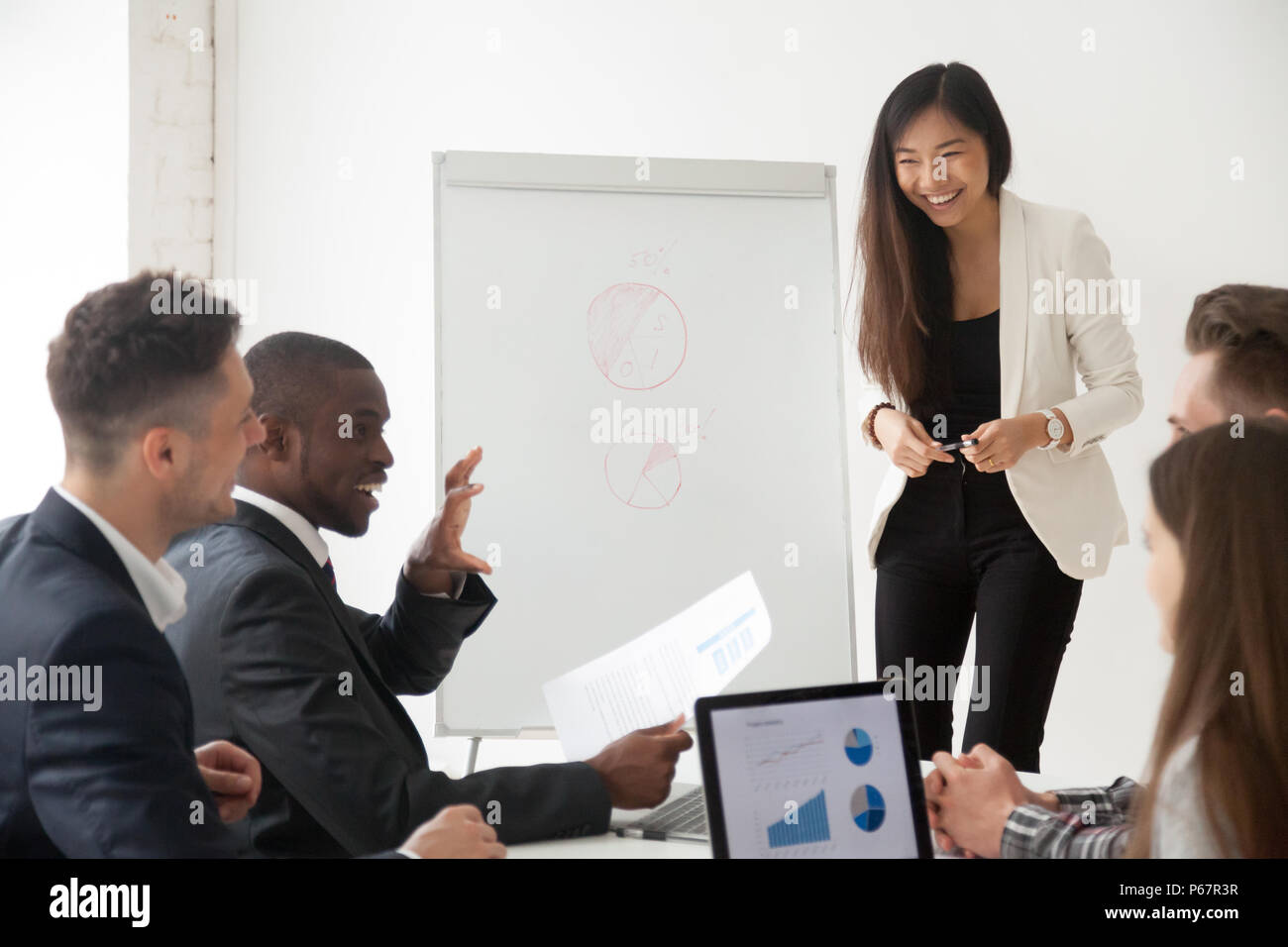 Asian coach making presentation on flipchart for diverse work gr Stock Photo