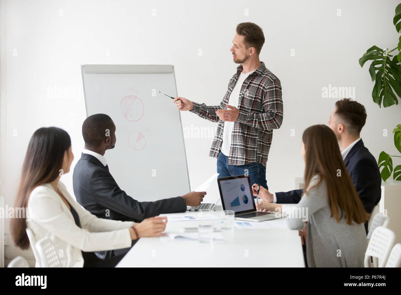 Male speaker making presentation on flipchart during meeting Stock Photo