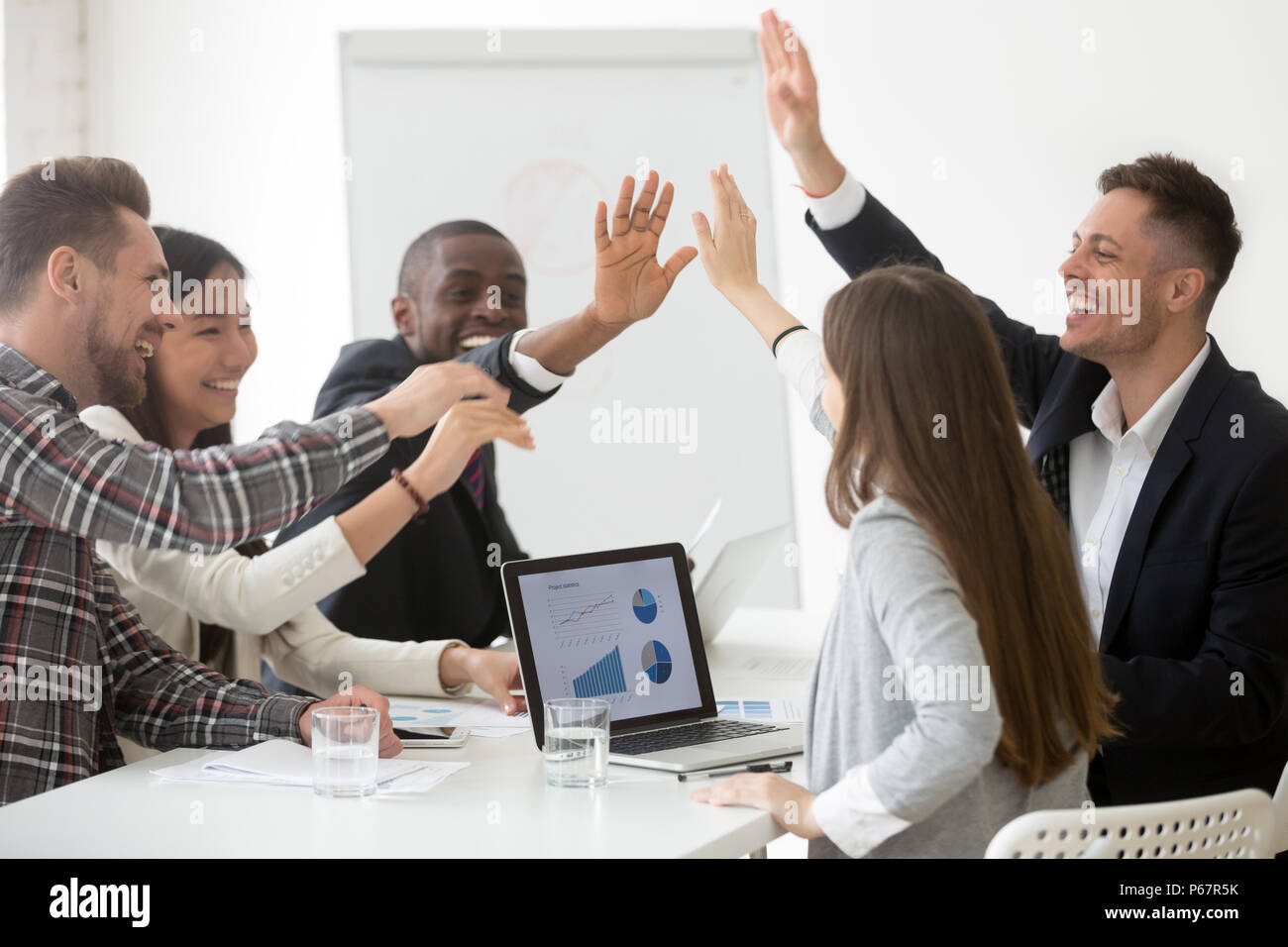 Excited team giving high five celebrating shared success Stock Photo