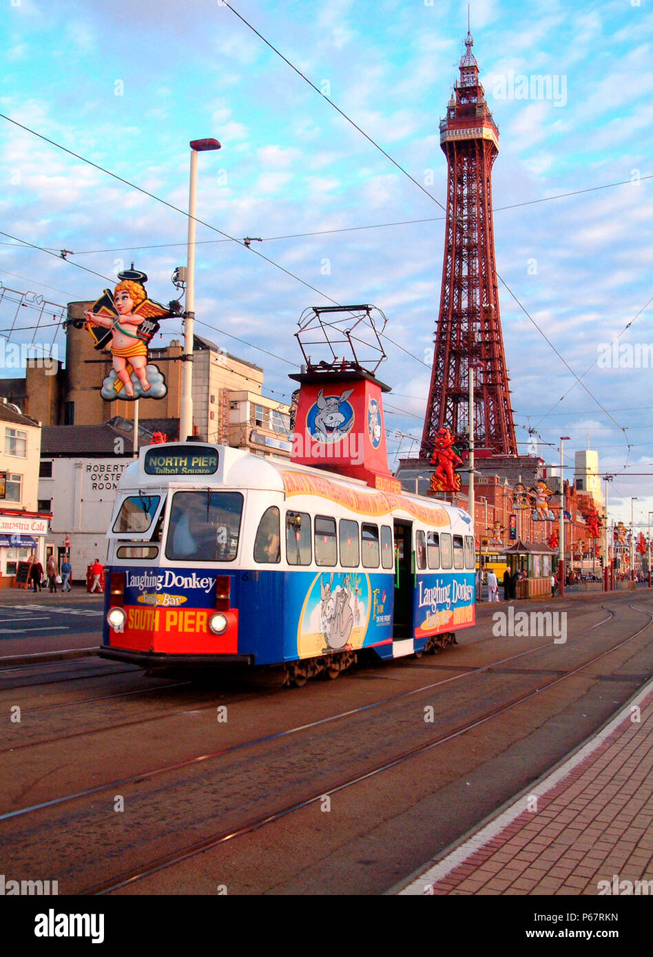 One of Blackpool's famous heritage trams traverses the promenade with Blackpool Tower in the background.July 2004. Stock Photo