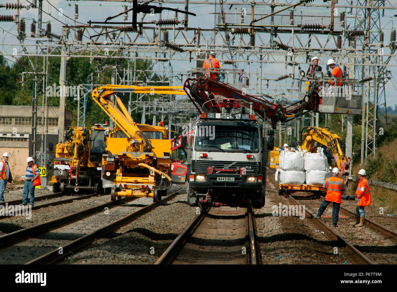Overhead Pickers Renewing the overhead catenary from cherry pickers mounted on road ...