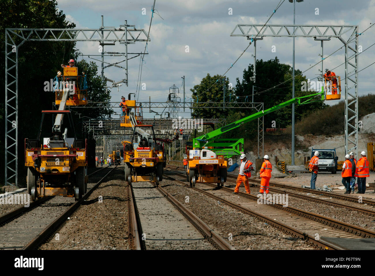 Overhead Pickers Renewing the overhead catenary from cherry pickers mounted on road ...