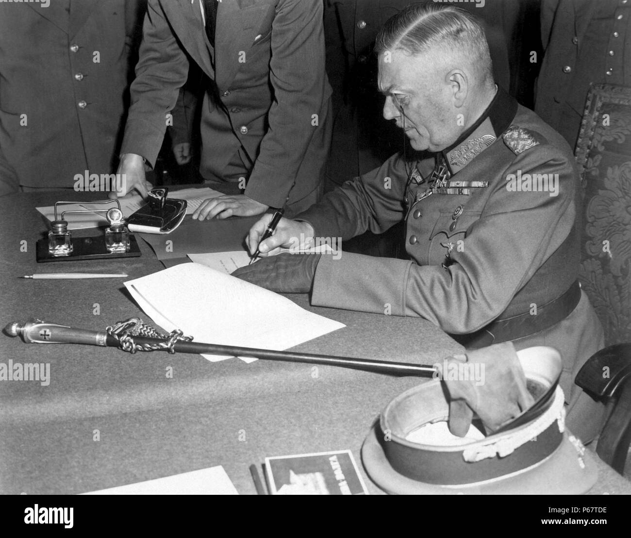 Photograph of Field Marshal Wilhelm Keitel (1882-1946) signing the ratified surrender terms for the German military in Berlin. Dated 1945 Stock Photo