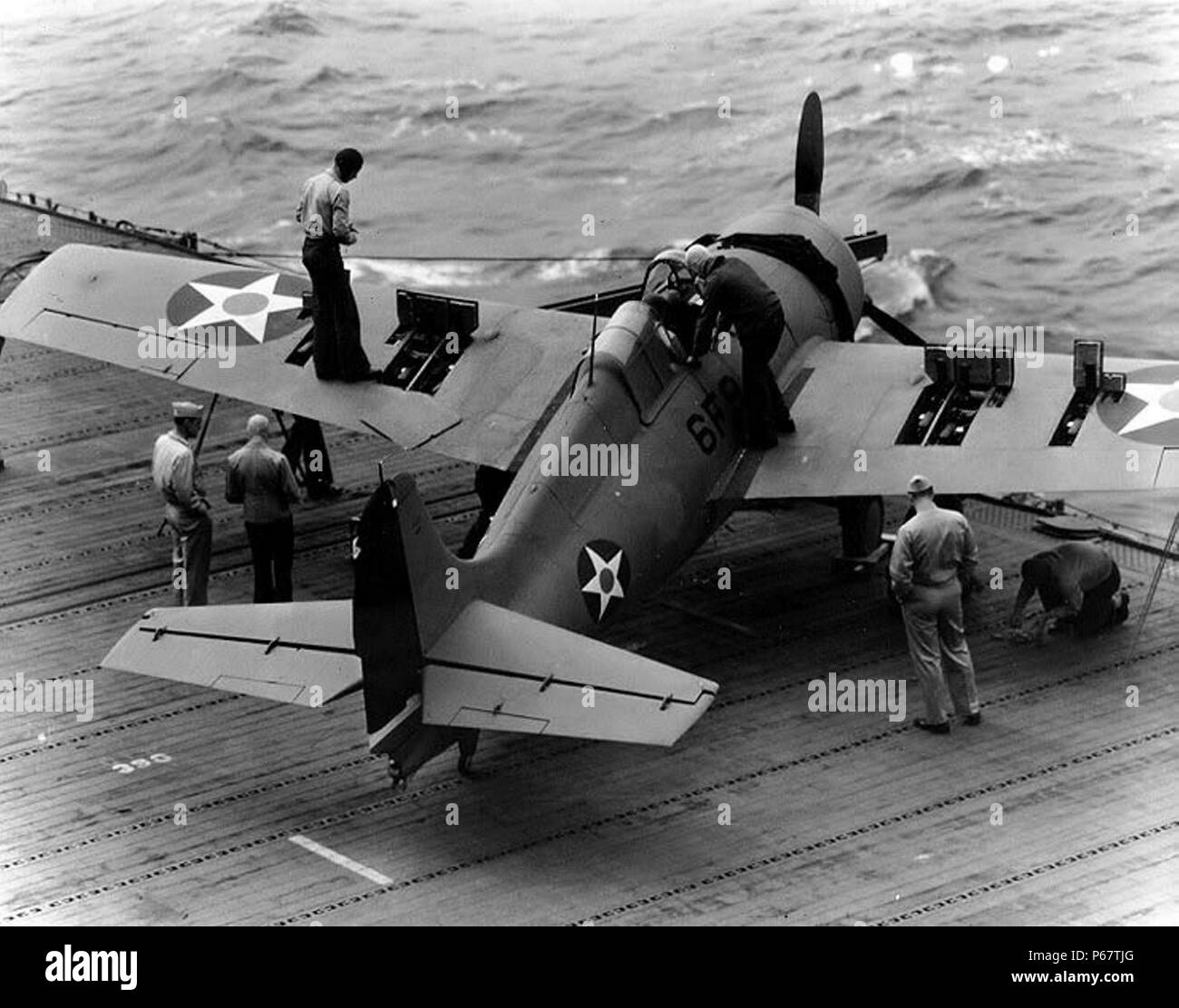 American World War Two fighter aircraft being maintained and repaired on board  a US aircraft carrier. Stock Photo