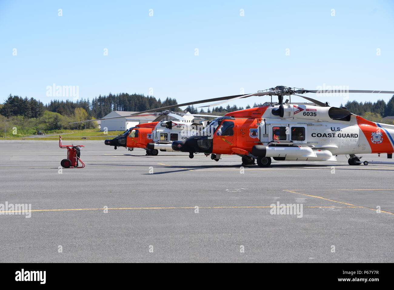 A pair of Coast Guard MH-60 Jayhawk helicopters sit on the flight line at Air Station Kodiak, Alaska on May 13, 2016. Stock Photo
