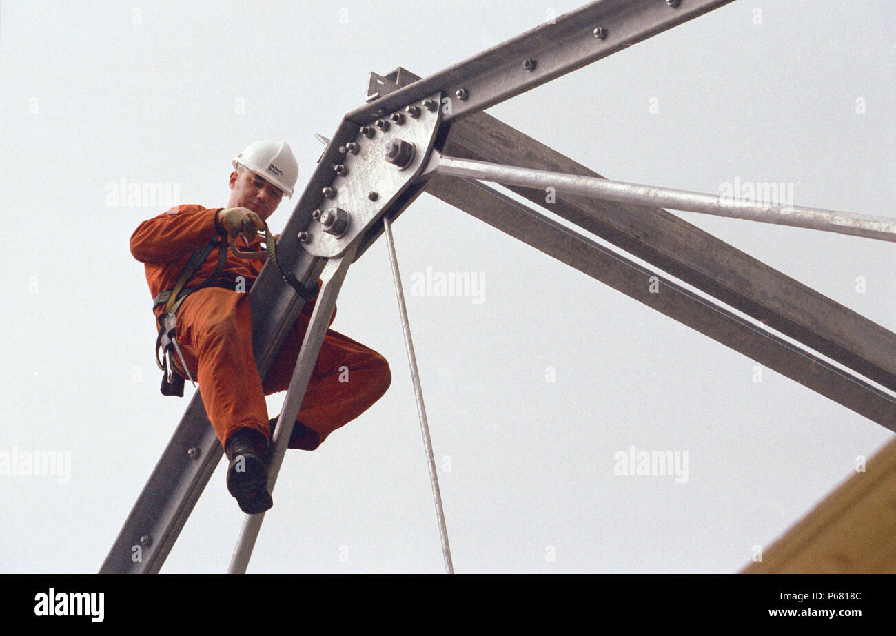 Roofing in progress. Construction worker attaching his safety belt on