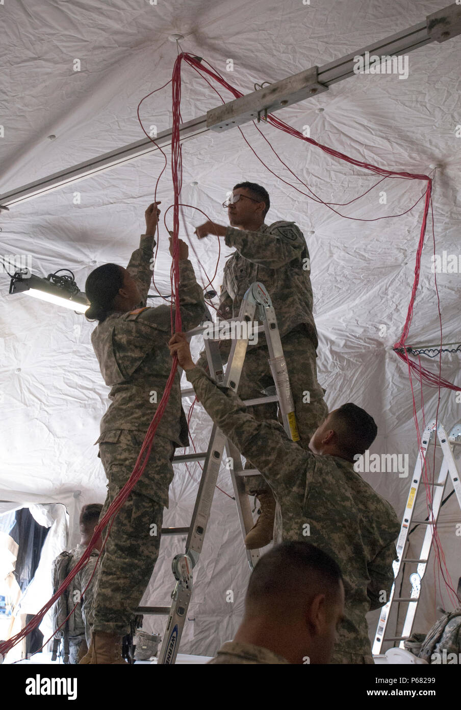 Soldiers from the California Army National Guard’s Headquarters Company, 224th Sustainment Brigade establish network connectivity within the unit’s state of the art Standard Integrated Command Post System during their 2016 annual training event at Camp Roberts, May 16. Housed within a 6,000 square-foot Deployable Rapid Assembly Shelter, the multi-tent complex will provide a fully operational control center capable of tracking each of the brigade’s assets and its movement throughout the state. (U.S. Army Photo by Staff Sgt. Melissa Wood/RELEASED) Stock Photo