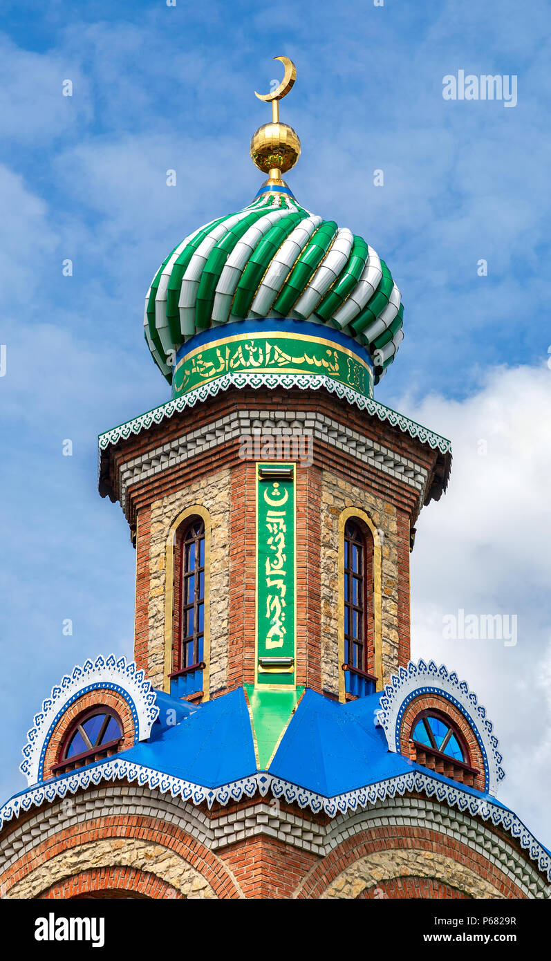 Tower with dome of islamic mosque against the blue sky Stock Photo