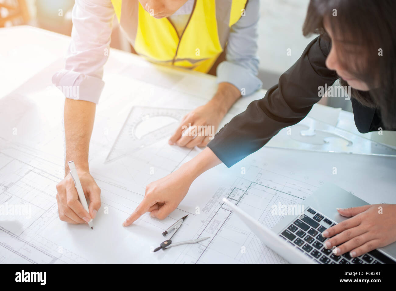 Hands of architects working on blueprints in the office, selective ...