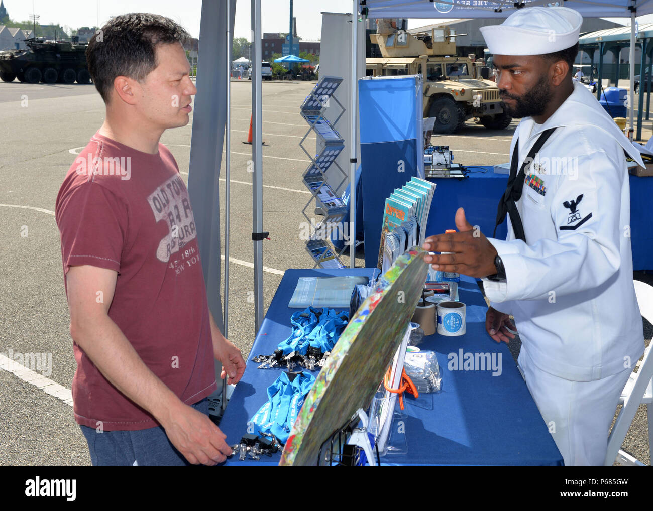 160528-N-IT235-001 NEW YORK (May 28, 2016) Culinary Specialist 3rd Class Jeffrey Harrison, from Cantonment, Fla., and stationed aboard the Arleigh Burke-class destroyer USS Farragut (DDG 99), explains plastic waste processing with a visitor at the 'Stewards of the Sea: Defending Freedom, Protecting the Environment' exhibit at the Brooklyn Cruise Terminal during Fleet Week New York 2016.  The Navy employs every means available to mitigate the potential environmental effects of our activities without jeopardizing the safety of our Sailors or impacting our Navy readiness mission. (U.S. Navy photo Stock Photo