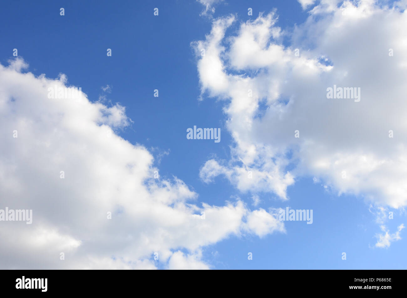 A blue sky with lots of white clouds of different sizes Stock Photo - Alamy