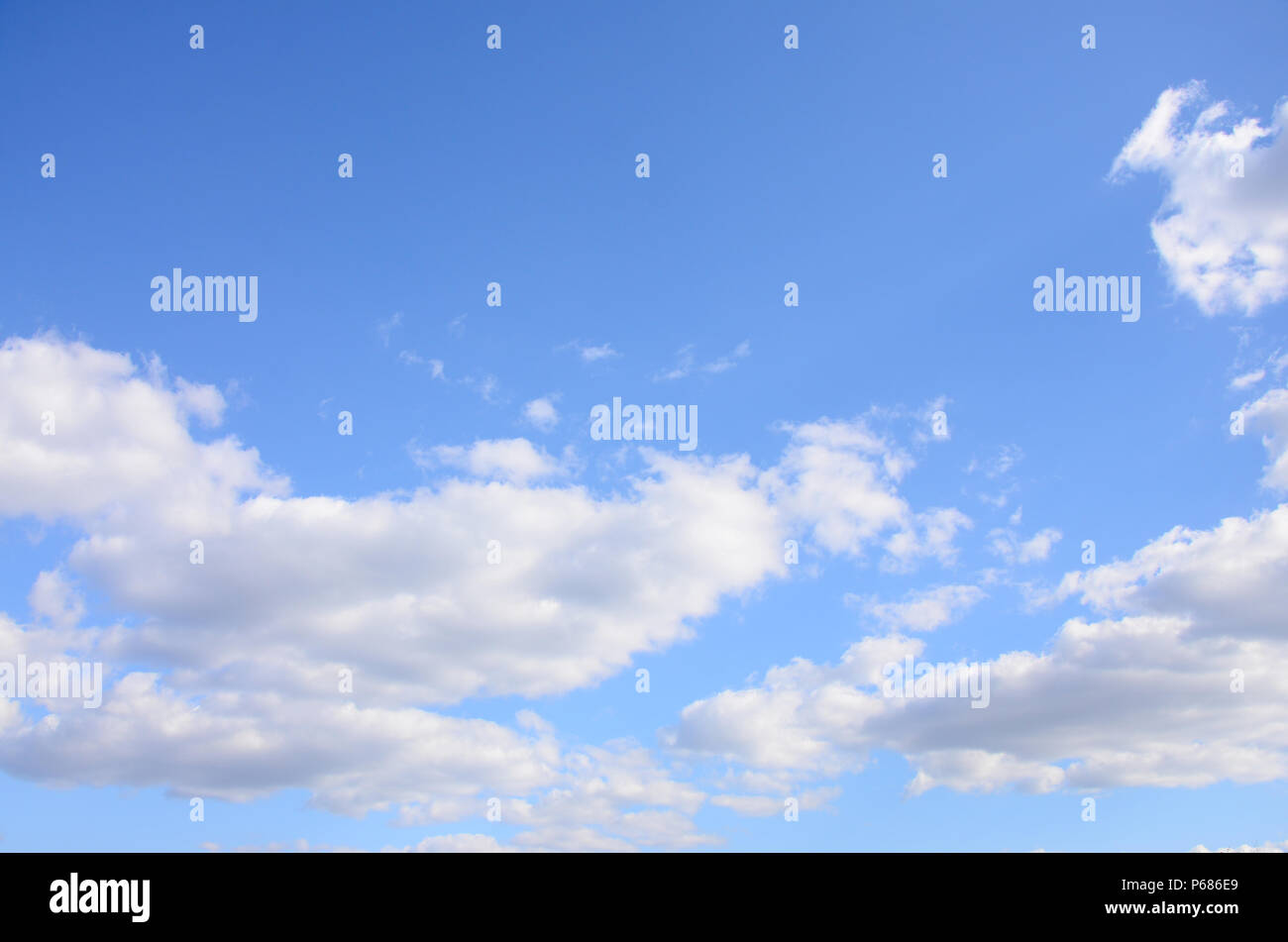 A blue sky with lots of white clouds of different sizes Stock Photo - Alamy