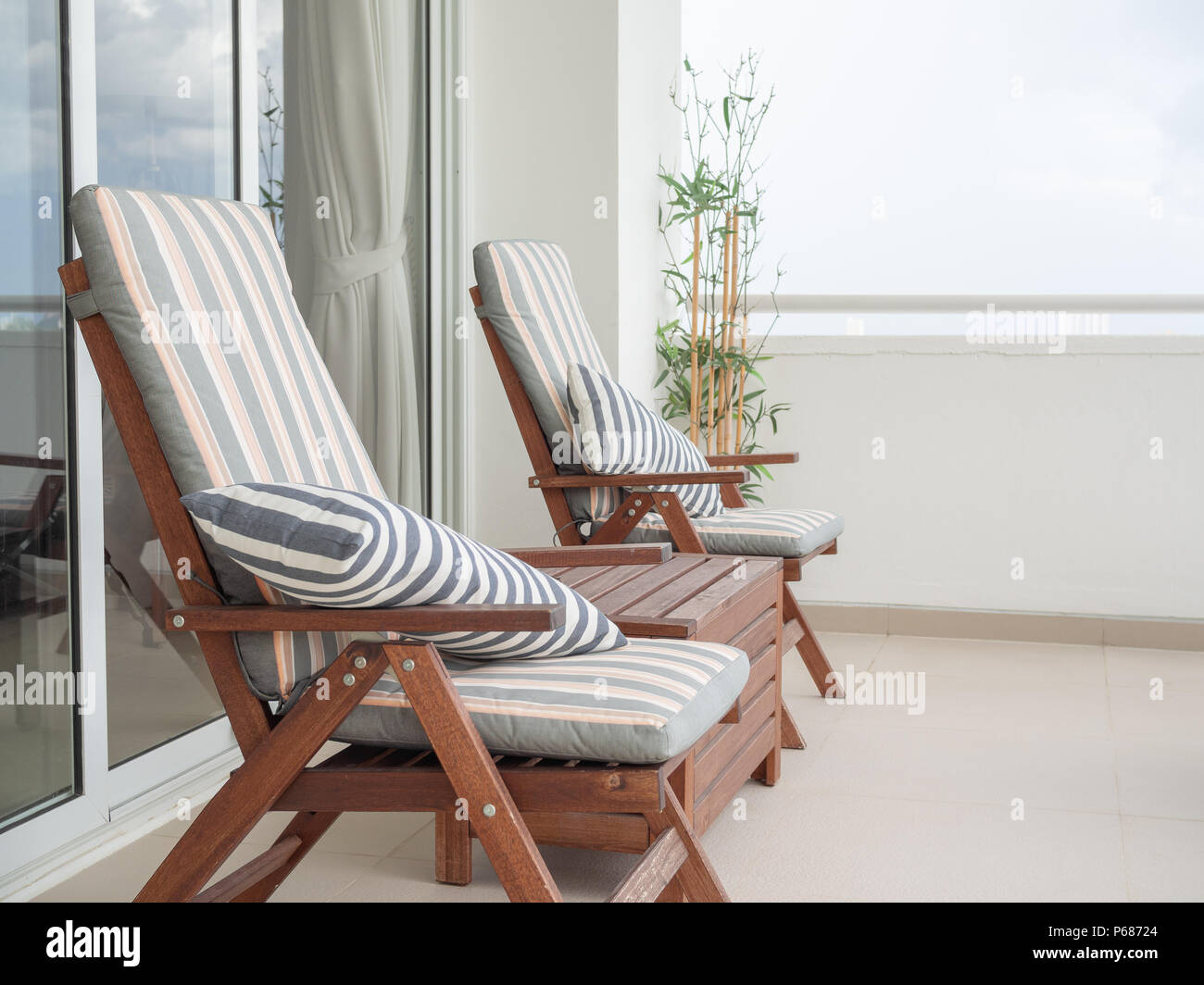 Wooden Sunbed with Pillows in The Terrace near Sliding Door and Bamboo