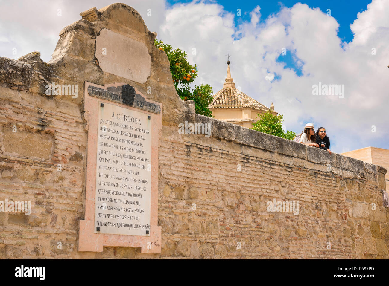 Andalucia Spain travel, view of two young women travelers leaning over the old city wall in Cordoba (Cordova), Andalucia, Spain Stock Photo