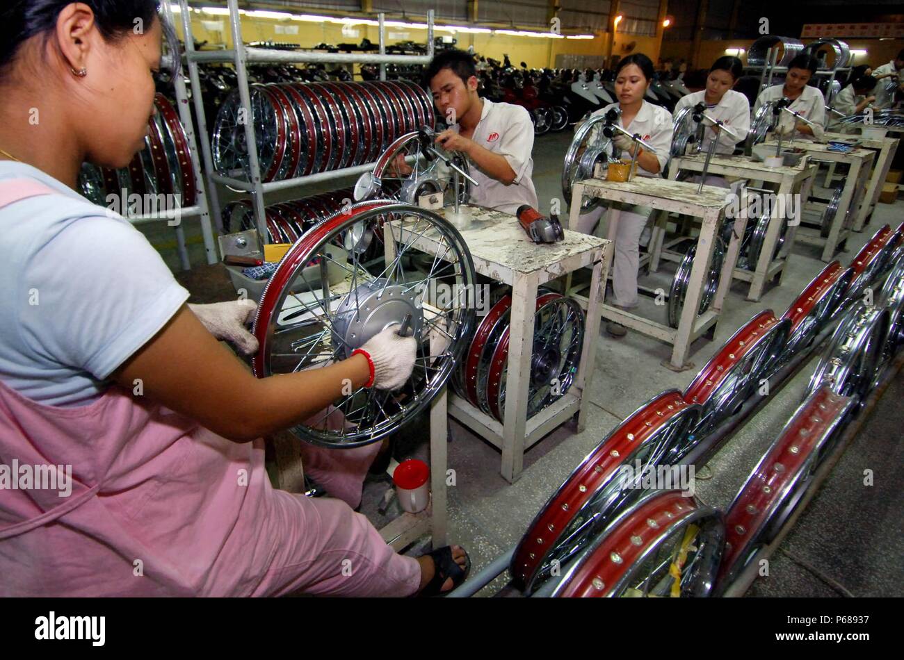 Beijing, Vietnam. 6th July, 2007. Vietnamese workers assemble motorcycle parts at a joint venture of Chinese motorcycle company Lifan, in Hung Yen Province, Vietnam, July 6, 2007. (TO GO WITH Xinhua Headlines: China's WTO entry a benefit to the world) Credit: Zhou Wenjie/Xinhua/Alamy Live News Stock Photo