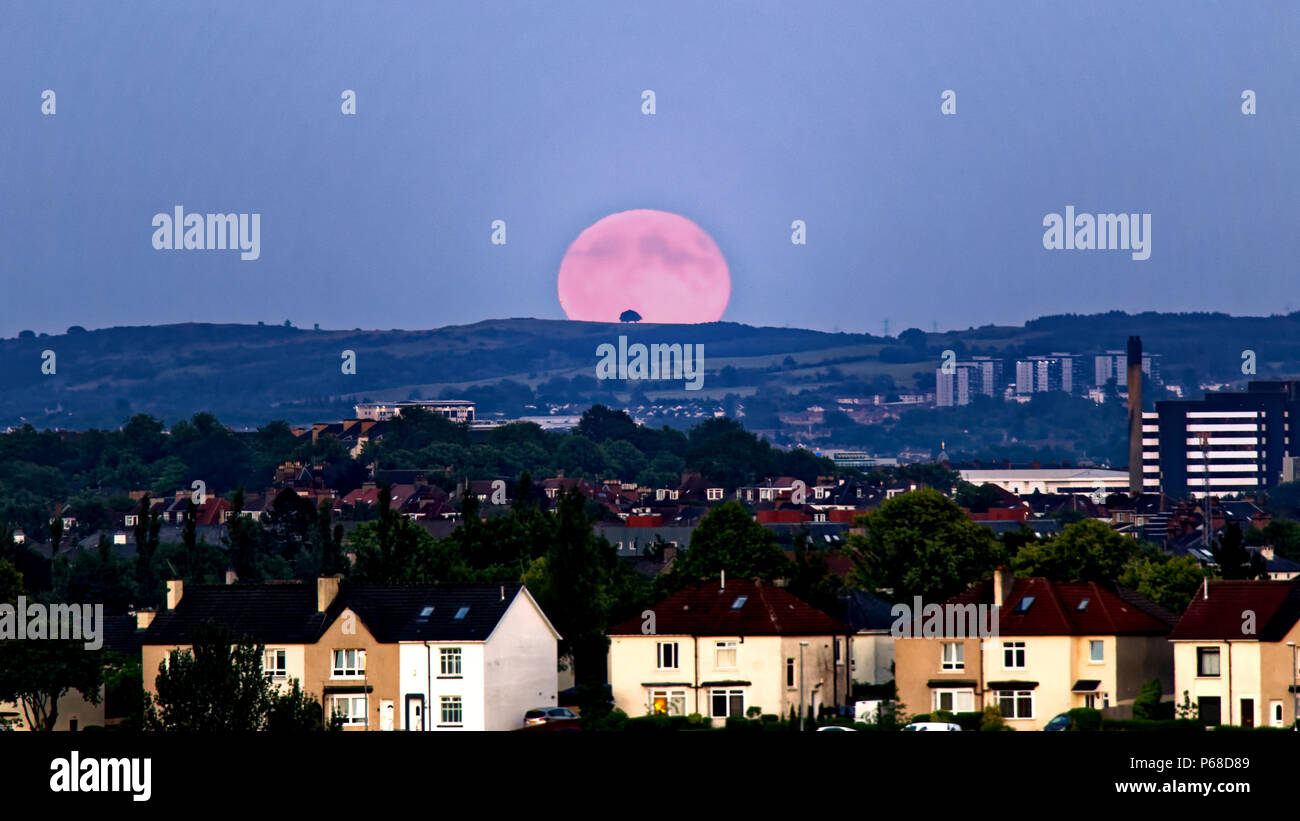 Glasgow, Scotland, UK 28th June. UK Weather:Sunny sizzling weather causes clear skies as a Strawberry full moon over the city appears over Cathkin braes and Dechmont hill also known as hot or mead moon or rose moon. Credit: gerard ferry/Alamy Live News Stock Photo