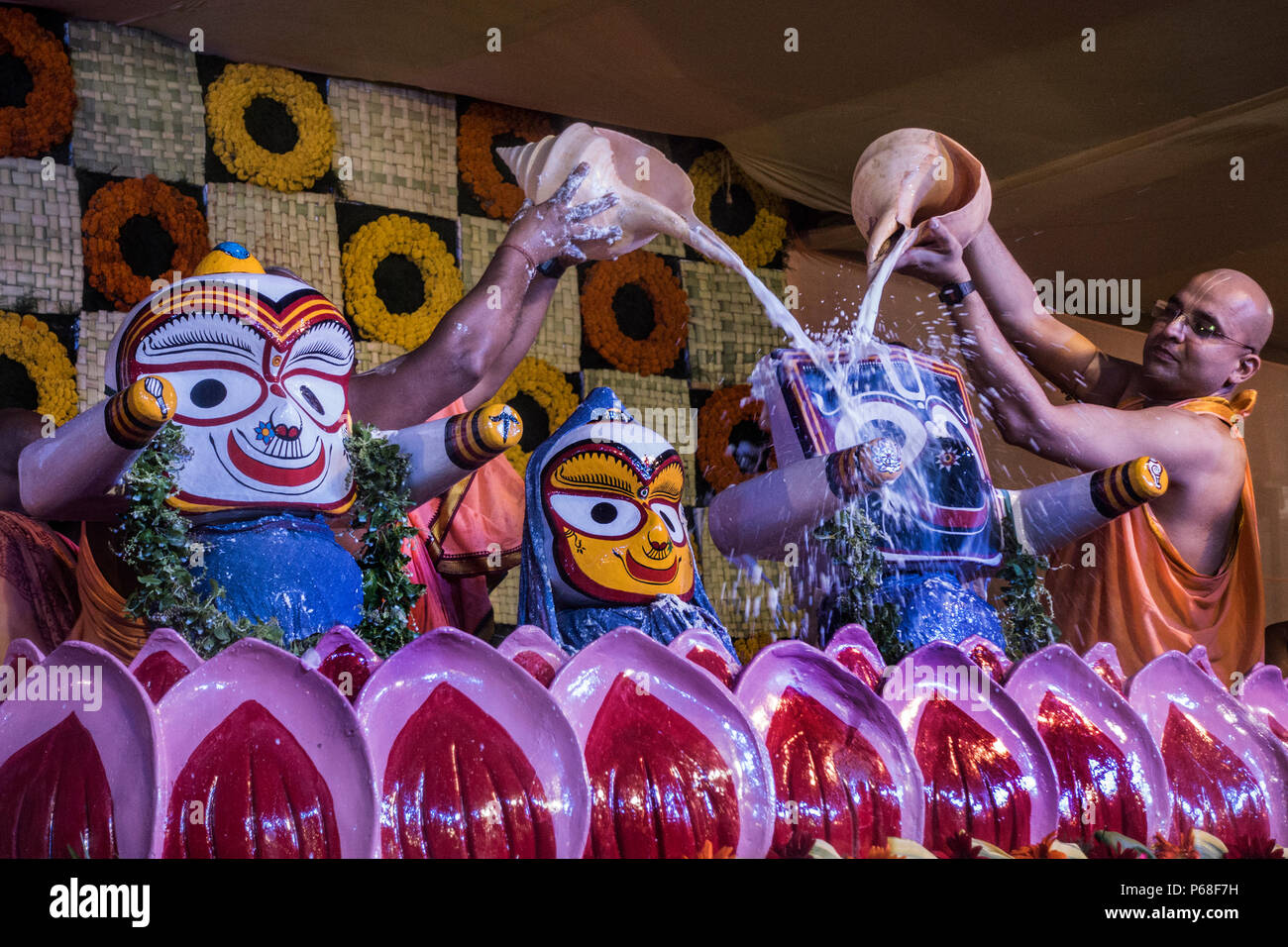 Kolkata, India. 28th June, 2018. Hindu priests pour milk atop of deities Lord Jagannath, Balabhadra and Subhadra during the bathing ceremony in Kolkata, India, on June 28, 2018. Credit: Tumpa Mondal/Xinhua/Alamy Live News Stock Photo