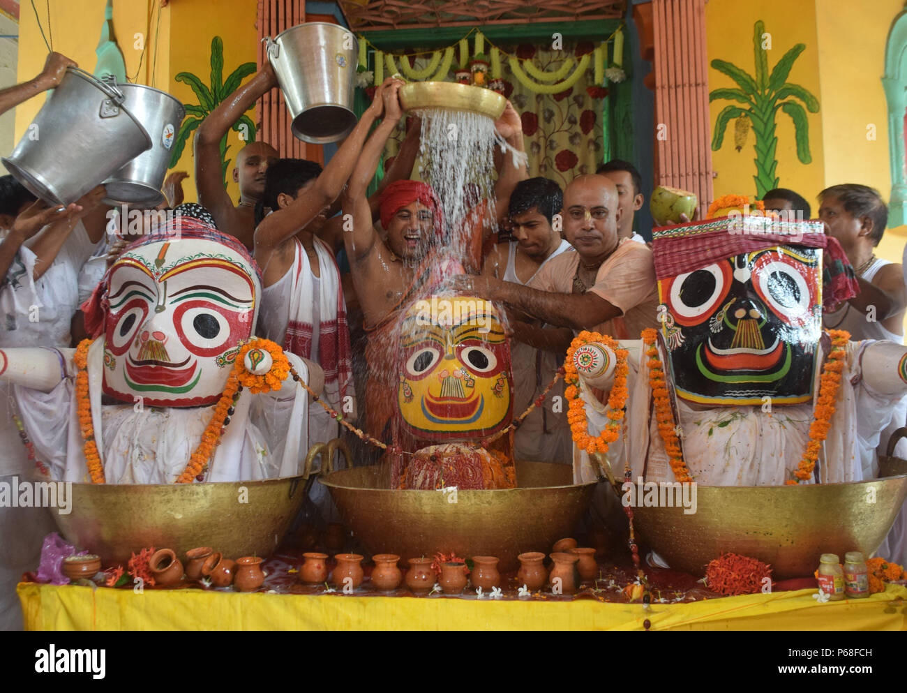 Tripura, Indian state of Tripura. 28th June, 2018. Hindu priests pour milk atop of deities Lord Jagannath, Balabhadra and Subhadra during the bathing ceremony in Agartala, capital of the northeastern Indian state of Tripura, on June 28, 2018. Credit: Stringer/Xinhua/Alamy Live News Stock Photo