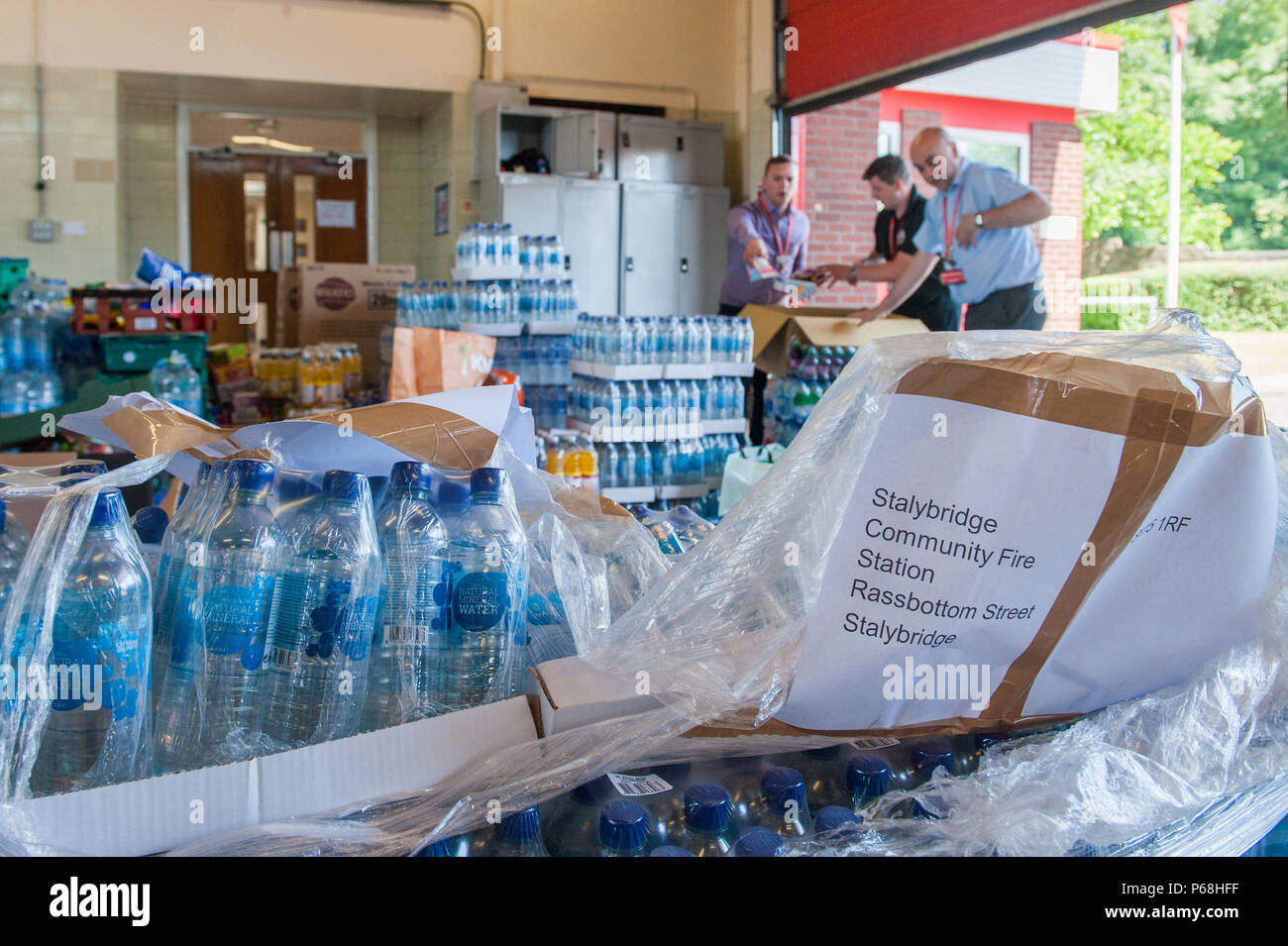 Stalybridge Fire Station, Greater Manchester, UK. 29th June, 2018. Staff and volunteers sort through a deluge of supplies including water and food given by the public and local businesses for the needs of firefighters tackling the huge blaze on Saddleworth Moor, at Stalybridge Fire Station, Greater Manchester on Friday 29th June 2018. Credit: Matthew Wilkinson/Alamy Live News Stock Photo