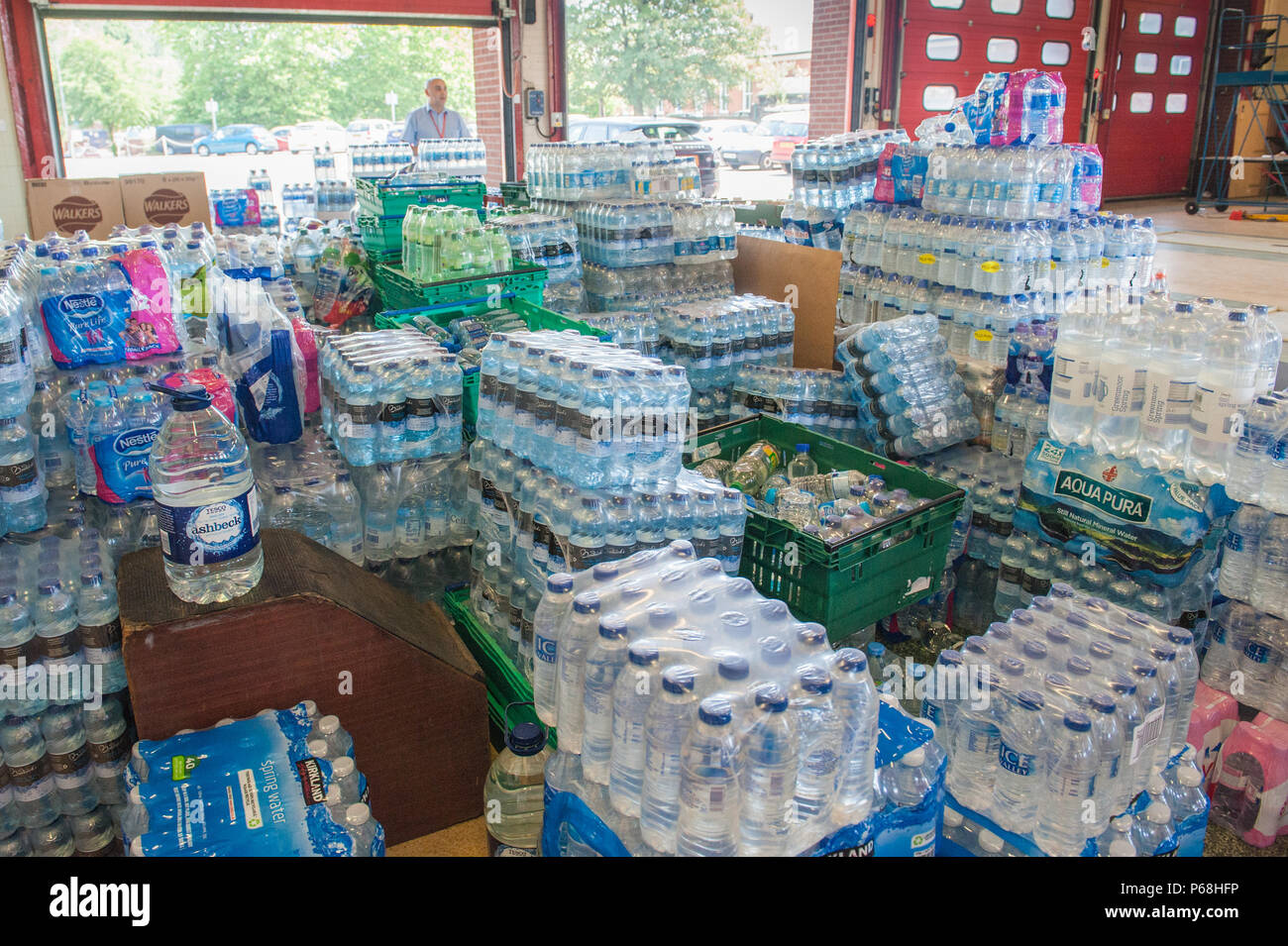 Stalybridge Fire Station, Greater Manchester, UK. 29th June, 2018. Staff and volunteers sort through a deluge of supplies including water and food given by the public and local businesses for the needs of firefighters tackling the huge blaze on Saddleworth Moor, at Stalybridge Fire Station, Greater Manchester on Friday 29th June 2018. Credit: Matthew Wilkinson/Alamy Live News Stock Photo