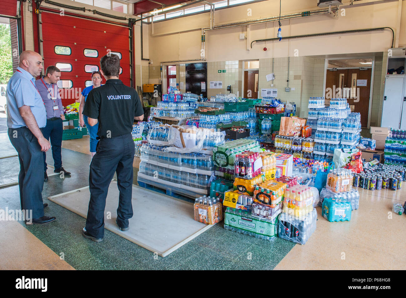 Stalybridge Fire Station, Greater Manchester, UK. 29th June, 2018. Staff and volunteers sort through a deluge of supplies including water and food given by the public and local businesses for the needs of firefighters tackling the huge blaze on Saddleworth Moor, at Stalybridge Fire Station, Greater Manchester on Friday 29th June 2018. Credit: Matthew Wilkinson/Alamy Live News Stock Photo