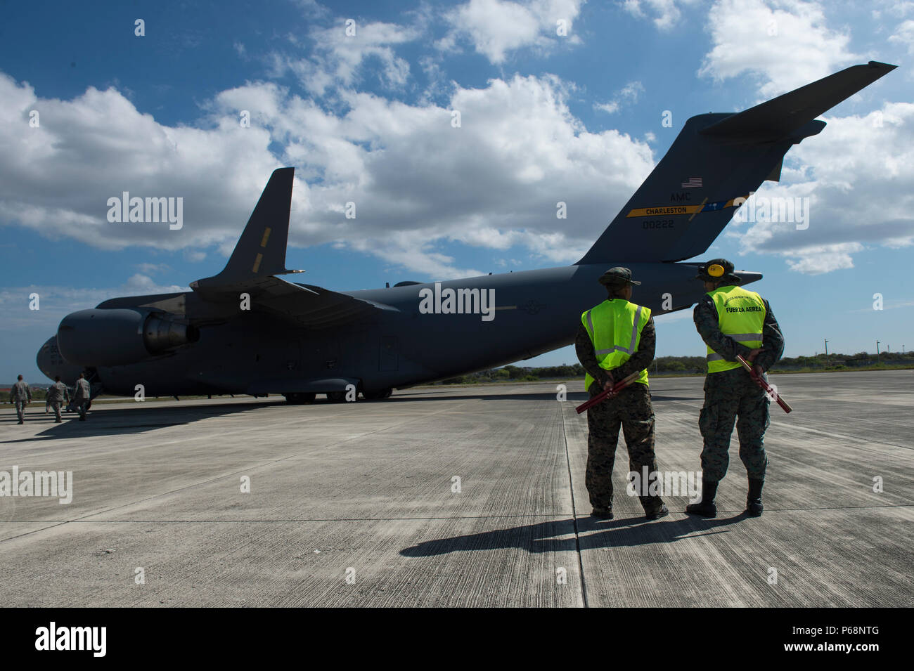 Ecuadorian military personnel stand watch over the airfield as a U.S. Air  Force C-17 Globe Master II, assigned to the 15th Airlift Squadron, is  unloaded at Alfaro International Airport, Ecuador, April 26,