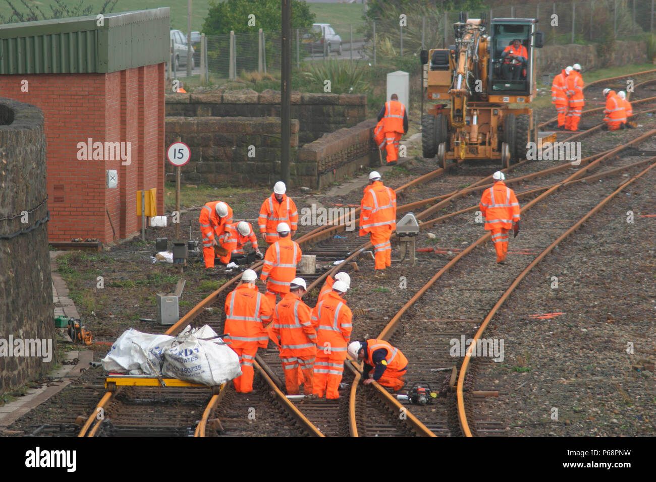 Track workers clear the flangeways and reset tracks at Penzance after the great storms of October 2004. Stock Photo