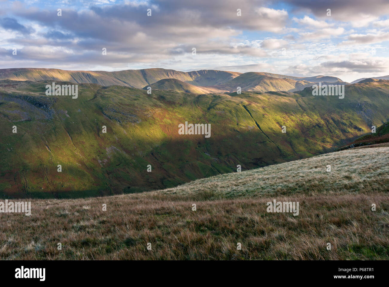 Evening sunlight on Beda Fell viewed from Place Fell with High Raise and High Street beyond in the Lake District National Park, Cumbria, England. Stock Photo