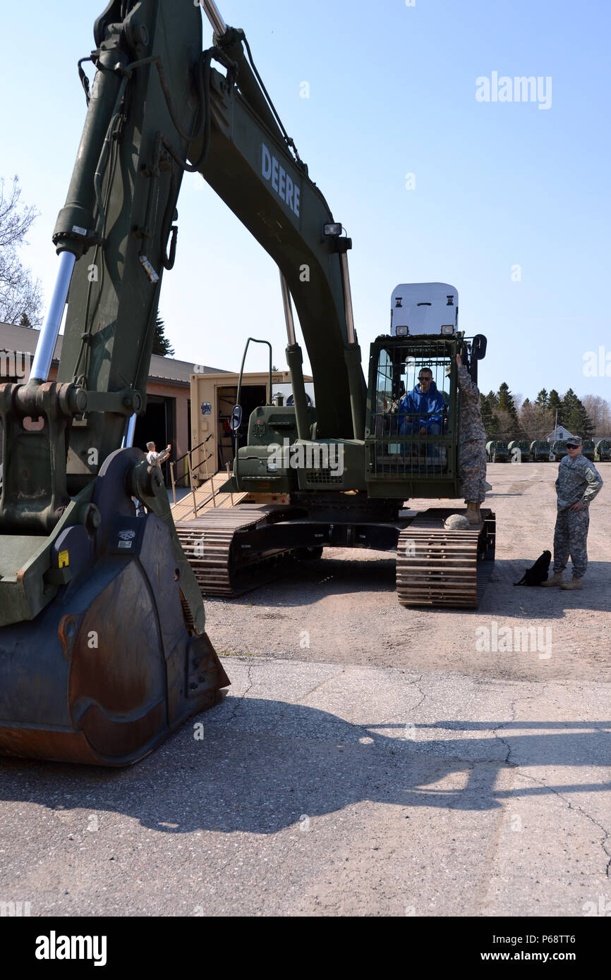 Spc. Paul Eddy, a member of the Sault Ste. Marie-based, 1437th Multi-Role Bridge Company, Michigan Army National Guard, talked with St. Ignace High School students about unit excavation capabilities and equipment, May 6, 2016, during a ‘Spend A Day With The Guard’ youth open house.  (Michigan National Guard photo by Angela Simpson/Released) Stock Photo