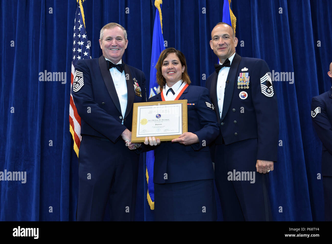 MCGHEE TYSON AIR NATIONAL GUARD BASE, Tenn. – Senior Airman Melissa Sherman, 445th Aerospace Medical Squadron, center, takes her diploma here May 18, 2016, as a distinguished graduate of the Airman leadership school, class 16-5, during the graduation banquet at the Chief Master Sgt. Paul H. Lankford Enlisted Professional Military Education Center. (U.S. Air National Guard photo by Master Sgt. Mike R. Smith/Released) Stock Photo