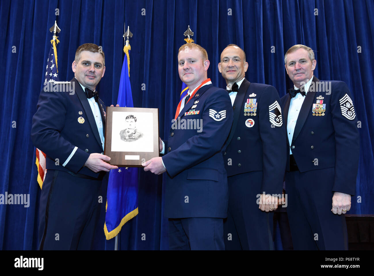 MCGHEE TYSON AIR NATIONAL GUARD BASE, Tenn. – Staff Sgt. Jason Savary, 193rd Special Operations Maintenance Readiness Squadron, center, takes the John L. Levitow award here May 18, 2016, for the Airman leadership school, class 16-5, during the graduation banquet at the Chief Master Sgt. Paul H. Lankford Enlisted Professional Military Education Center. (U.S. Air National Guard photo by Master Sgt. Mike R. Smith/Released) Stock Photo