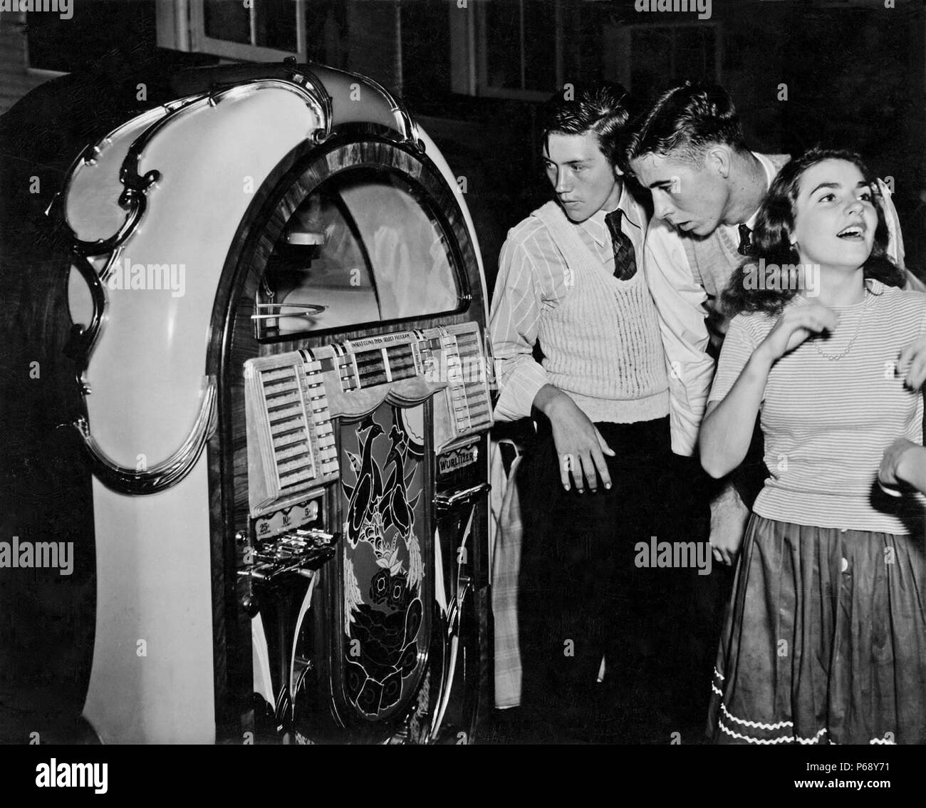 Photograph of young americans gathered next to a Jukebox in a Dance hall in Richwood, West Virginia. Dated 1942 Stock Photo